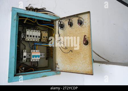 Power distribution board. Electrical panel with a row of fuses for different areas in a building, set against a white wall Stock Photo