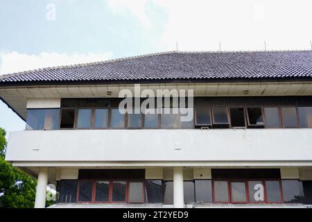 Clear view of the deteriorated section of an old building, showcasing a row of aged, damaged windows and shattered glass Stock Photo