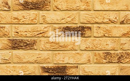Old beige color stone material brick wall pattern background Stock Photo