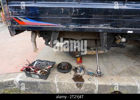 Truck drum brake system undergoing repair, showcasing a slightly chilling scene with a hanging doll beneath the vehicle Stock Photo