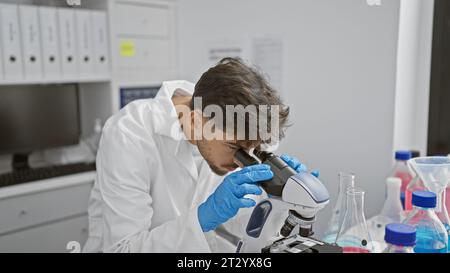 Young arab man scientist using microscope at laboratory Stock Photo