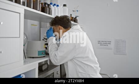 Young arab man scientist using microscope at laboratory Stock Photo