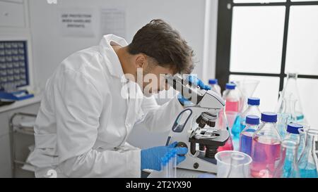 Young arab man scientist using microscope at laboratory Stock Photo