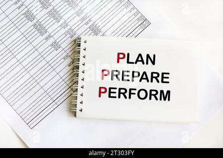 PLAN PREPARE PERFORM text on notepad and white background Stock Photo