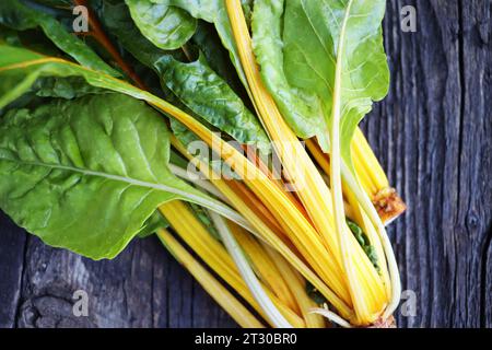 Fresh raw swiss rainbow chard leaves on wooden background. Top view . Stock Photo
