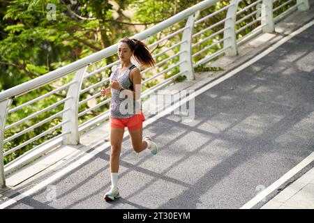 young asian woman running jogging outdoors in park Stock Photo