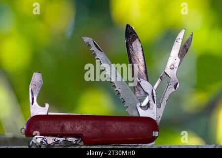 Swiss knife, used, dirty, pictured in nature. Stock Photo