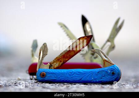 Swiss knife, used, dirty, pictured in nature. Stock Photo