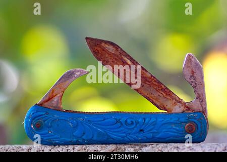 Swiss knife, used, dirty, pictured in nature. Stock Photo
