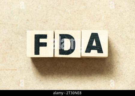 Alphabet letter block in word FDA (abbreviation of food and drug administration) on wood background Stock Photo