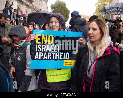 Pro-Palestinian marchers  in London, UK, at the National March for Palestine  demonstration Stop the war on Gaza, march to protest about the Israel Palestine confict over the Gaza Strip. Protesters marching to Downing street  with end israeli apartheid posters placards. Stock Photo