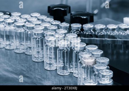 Pharmaceutical industry. Production line machine conveyor with glass bottles ampoules at factory. Pharmaceutical industry concept background. Stock Photo