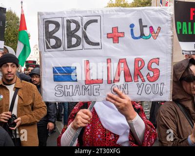 Pro-Palestinian marchers  in London, UK, at the National March for Palestine  demonstration Stop the war on Gaza, march to protest about the Israel Palestine confict over the Gaza Strip. Protesters with Anti BBC and Anti ITV poster placard protesting about coverage of Gaza conflict on UK television TV news channels Stock Photo