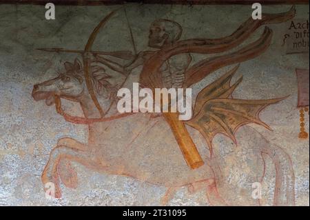 Death as an archer on a galloping stallion, quiver of arrows at his side.  Detail from Renaissance Danza Macabra (Dance of Death) fresco frieze, painted in 1539 by Simone II Baschenis (c. 1495-1555) on an outside wall of the Chiesa di San Vigilio (Church of Saint Vigil or Vigilius), Pinzolo, Trentino-Alto Adige, Italy. Stock Photo