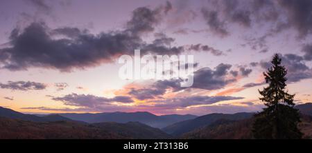 dramatic cloudscape above the mountains at dusk. sky in colorful evening light. changing weather forecast Stock Photo