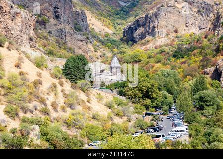 Goght, Armenia - September 30, 2023: road with parked cars to Monastery of Geghard in Upper Azat Valley on sunny autumn day. Geghard is listed as UNES Stock Photo