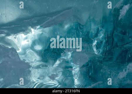 Texture of frozen ice of a mountain lake. The thickness of green-blue ice through which light is visible Stock Photo