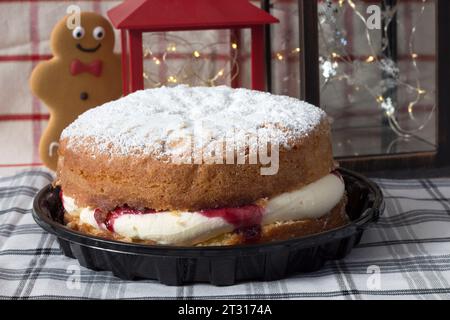 Happy gingerbread man looking at Victoria sponge cake Stock Photo