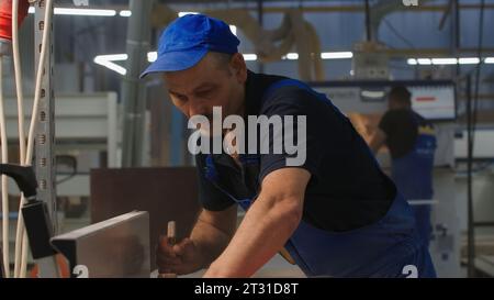 Workers at factory with machines. Creative. Workers are engaged in design and assembly at factory. Workers are preparing new project and working with Stock Photo