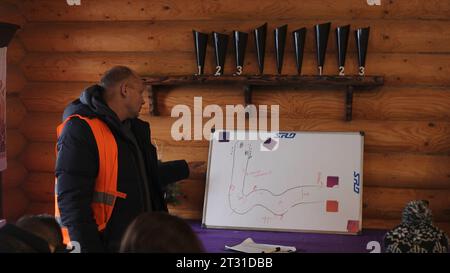 Serbia, Belgrade - December 20, 2022: Man explains theory with blackboard. Clip. Instructing safe race route on board. Man explains basics of driving Stock Photo