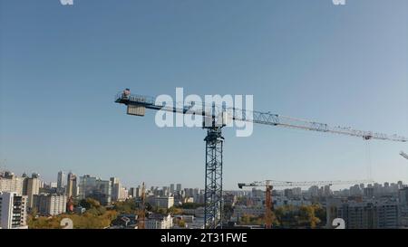 Top view of construction crane on background of city on sunny day. Stock footage. Construction cranes at height with view of city to horizon Stock Photo