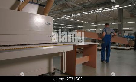 Delhi, India - April 29, 2023: Work in a factory. Stock footage. Workaholics in special clothes make furniture and boards with the help of special Stock Photo