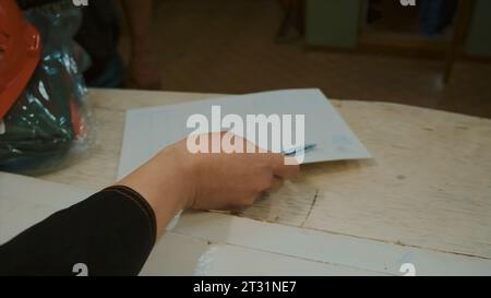 Elderly woman takes notes in laboratory. Clip. Female dispatcher in uniform writes in log. Dispatcher records data on devices in technical log Stock Photo
