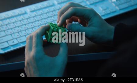 Man holding abstract cube in hands. Stock footage. Close-up of man holding puzzle cube. Man holds puzzle cube at office desk Stock Photo