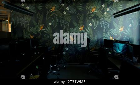 Empty office room after working day with lights off. Stock footage. Modern office with computers and decorative wall. Stock Photo