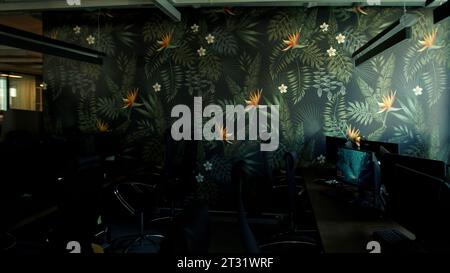 Empty office room after working day with lights off. Stock footage. Modern office with computers and decorative wall. Stock Photo