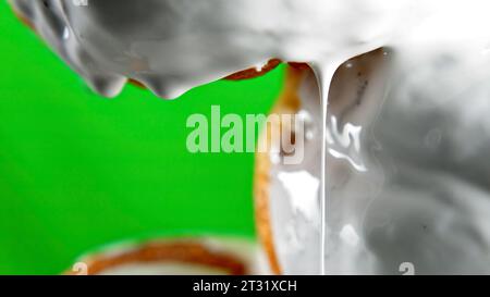 Close up of freshly baked cinnamon rolls. Sweet cream cheese frosting pouring on cinnamon rolls, bakery products. Stock Photo