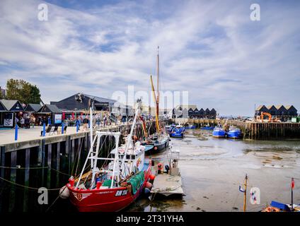 Editorial Use Only - Low tide in Whitstable harbour, fishing boats moored at the quayside, Whitstable, Kent UK Stock Photo