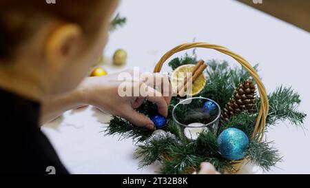 Close up of small basket with pine tree branches and toy balls. Art. Christmas decorations, concept of winter holidays. Stock Photo