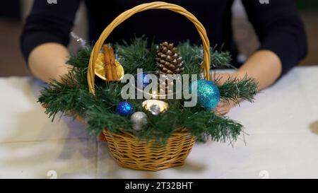 Close up of small basket with pine tree branches and toy balls. Art. Christmas decorations, concept of winter holidays. Stock Photo