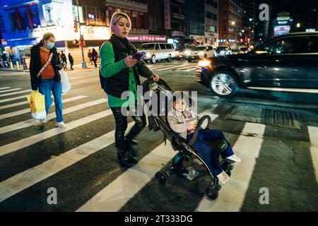 new york, usa - september 12th 2023 young mother with a stroller at a pedestrian crossing. High quality photo Stock Photo