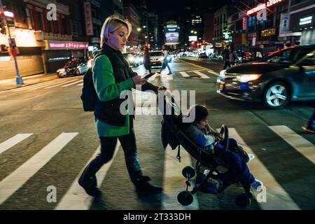 new york, usa - september 12th 2023 young mother with a stroller at a pedestrian crossing. High quality photo Stock Photo