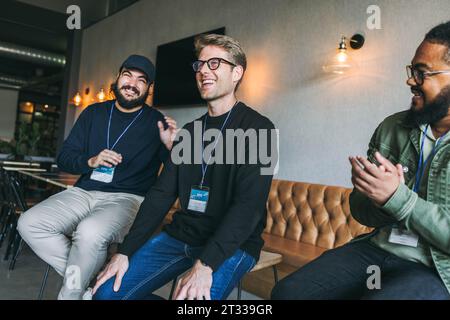 Colleagues in a business conference meeting show teamwork and networking skills in an office environment. Smiling and happy, young men work together a Stock Photo