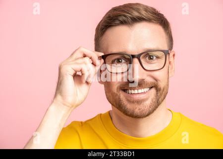 Friendly cheerful middle-aged unshaved man touching glasses and looking at camera pleasantly smiling Stock Photo