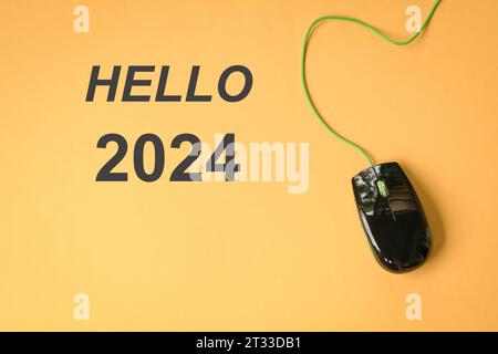 Hello 2024 with computer mouse. Top view. On yellow background. Stock Photo