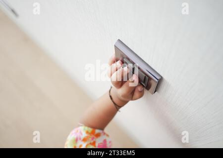 child finger turning on lighting switch with copyspace  Stock Photo