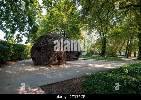 Blonie, Poland - August 20, 2023: Wicler construction looking like nests as a part of park, recreation infrastructure. Pavement made of wooden planks. Stock Photo