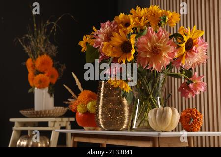 Room decorated with pumpkins and bright flowers, space for text. Autumn vibes Stock Photo