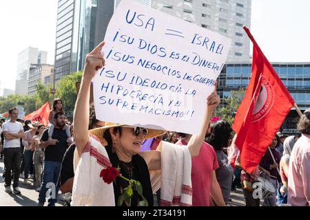 Pro-Palestine march, Mexico City, Mexico. 22nd Oct, 2023. a woman wearing a rose holds a banner saying 'USA = Israel. Your God is money. Your business is war. Your ideology is hypocrisy and supremacy'. Thousands of people protest in Mexico City, whilst repeatedly chanting ÕItÕs not a war. ItÕs Genocide'. Many people waved Palestinian flags, others wore a keffiyeh in solidarity with the people of Palestine. Various groups formed part of the march including the Mexican Communist Party, pro-abortion activists and LGBTQ  groups. Credit: Lexie Harrison-Cripps/Alamy Live News Stock Photo