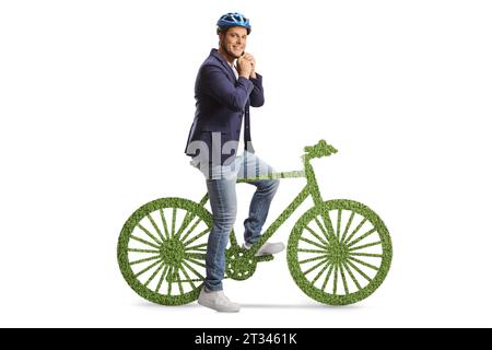 Man sitting on a green bicycle and putting on a helmet isolated on white background Stock Photo