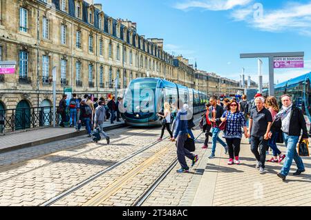 Passengers arriving and queuing to catch and depart from a Transports Bordeaux Métropole (TBM) tram in Bordeaux, a port city in southwestern France Stock Photo