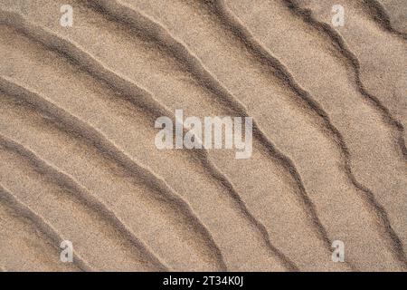 Sand bottom with wavy pattern on a beach in close-up Stock Photo