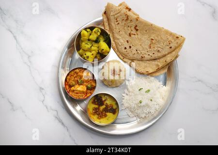 Indian vegetarian Thali or platter includes Aloo ki sabji, dal rice, Roti bhaji, Matar Paneer, Sheera or suji ka halwa, chapati. Indian food, sheera. Stock Photo