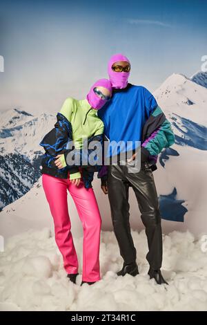 beautiful couple posing together wearing pink balaclavas and stylish sunglasses, winter concept Stock Photo