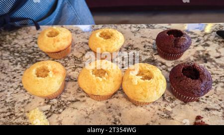 Filling Vanilla, Chocolate Cupcakes with Lemon, Raspberry Stock Photo