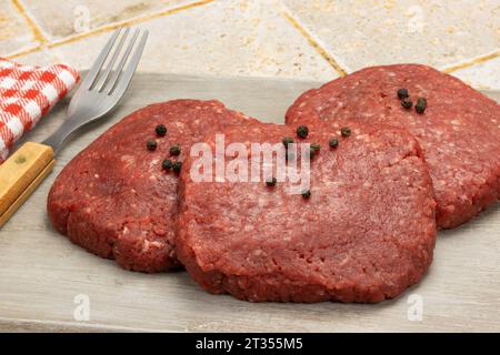 raw beef minced steaks, close-up, isolated on a table Stock Photo